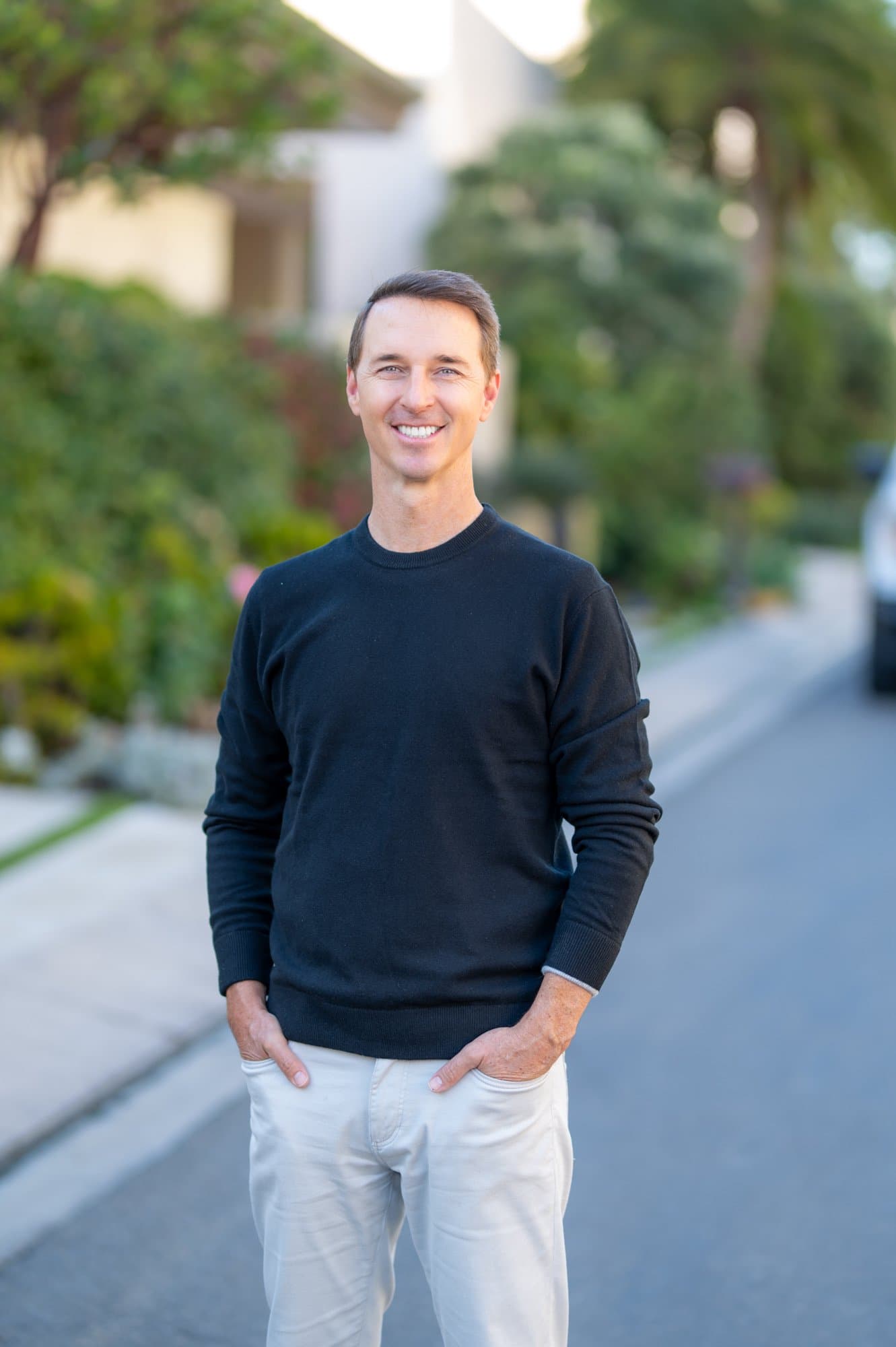 Brad Cook, a Genova founder and principal, standing on a tree-lined residential street.